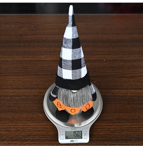 Detailed view of Halloween gnome decoration weighing 150.3g on a scale with BOO banner