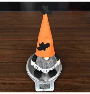 Weight display of Halloween gnome with orange hat and BOO banner on a digital scale