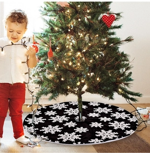 Detailed view of grey plush Christmas tree skirt with white snowflake patterns in cozy scene