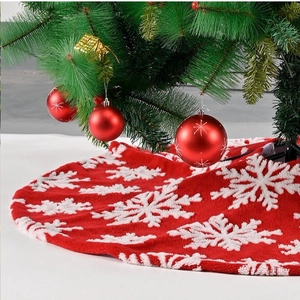 Classic red Christmas tree skirt with white snowflake patterns and plush fabric finish