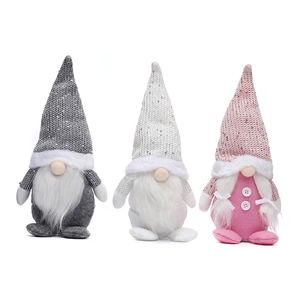 Détail de trois gnomes de Noël en peluche avec bonnets à paillettes gris et roses