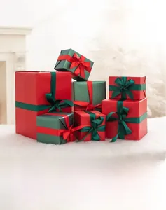 Detail of red and green Christmas gift boxes with ribbons on white plush surface