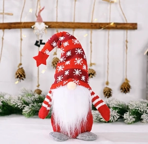 Détail d'un gnome de Noël portant un bonnet tricoté rouge à flocons et étoile décorative