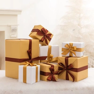 Champagne gold and white Christmas gift boxes with satin ribbons on white plush rug