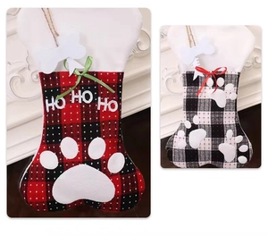 Close-up of plaid bone-shaped pet Christmas stockings with paw prints and HO HO HO text