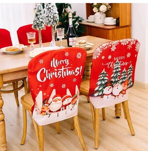 Detail of red Santa Claus and snowman chair covers in a festive dining room setting