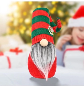 Christmas gnome plush with red green striped knit hat and festive wreath decoration