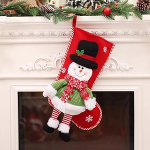 Close-up of red Christmas stocking with 3D snowman doll hanging on white fireplace
