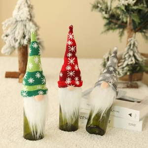 Close-up of Christmas gnome wine bottle covers with knitted snowflake hats and white beards