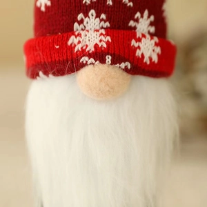 Close-up of a Christmas gnome wine cover with a red knitted hat and white beard detail