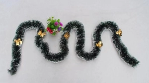 Dark green Christmas tinsel with snow-white tips and five decorative gold bows