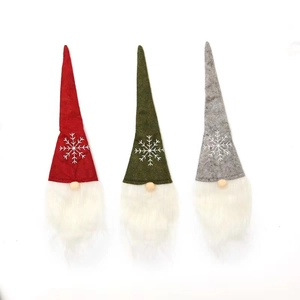 Set of three Christmas gnomes with snowflake hats in red, green and grey colors