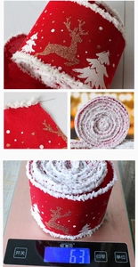 Close-up of red Christmas ribbon with gold deer, white snow flakes and soft fuzzy edges