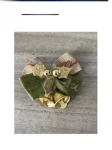 Detail of burlap Christmas bow with golden bells and Merry Christmas print