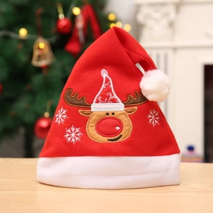 Bonnet de Noël rouge festif avec broderie de renne blanche posé sur une table en bois