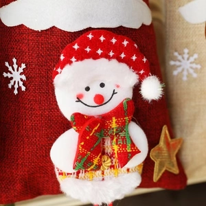 Macro shot of 3D plush snowman on a red burlap Christmas gift bag with star details