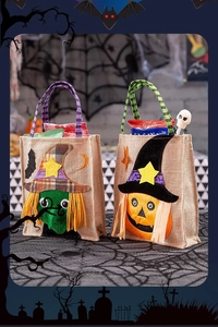 Detail view of burlap Halloween treat bags with witch and pumpkin appliques on a themed table