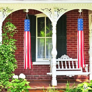 Detail view of two American flag wind socks hanging on a classic porch for outdoor decoration