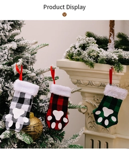 Detailed view of red and green plaid Christmas stockings with white pet paw prints
