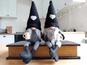 Pair of Christmas faceless gnomes with coffee cups and heart hats for home decoration