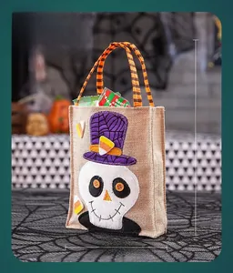 Detail of Halloween burlap gift bag with skull embroidery and striped orange handles