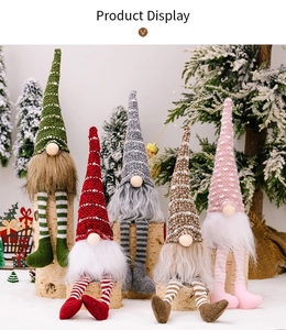 Close-up of five Christmas gnomes with striped legs on birch logs and snowy backdrop