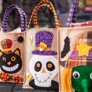 Halloween burlap gift bags featuring cartoon cat, skeleton and witch party designs