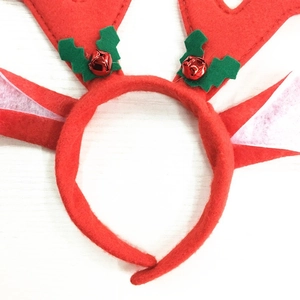 Close-up of a festive red reindeer antler headband with green leaves and small bells