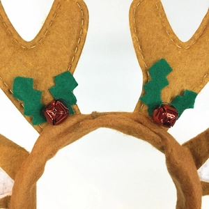 Close-up of brown plush reindeer antlers with green leaves and red jingle bells details