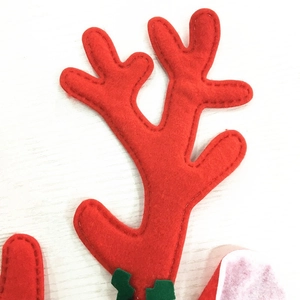 Detailed view of red felt Christmas reindeer antlers with green leaf and stitching