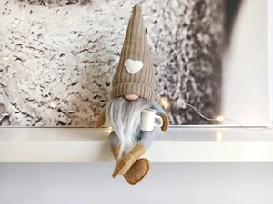 Detail of a Nordic Christmas gnome sitting on a shelf with warm ambient fairy lights