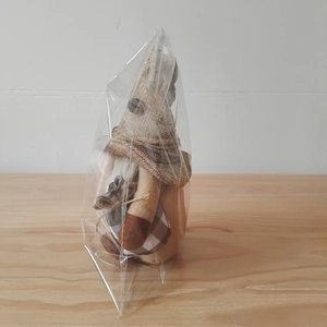 Detail of a rustic coffee gnome plush with burlap hat and checkered outfit in packaging