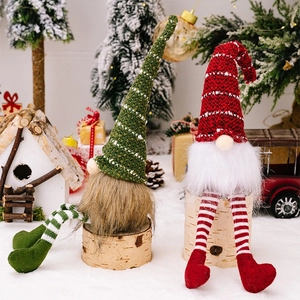 Detail of Christmas gnome dolls with striped knit hats and long legs in a snowy scene