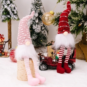 Close-up of plush Christmas gnomes with striped long legs and knitted hats on display