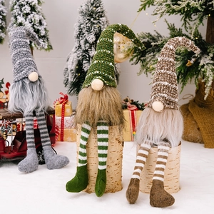 Three Christmas long-legged gnomes with striped hats and plush beards for holiday decor