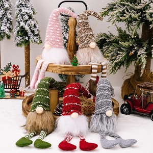 Detailed view of five colorful knit Christmas gnomes with long hanging striped legs