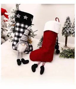 Detail of plush red and black plaid Christmas stockings with cute gnome and long dangling legs