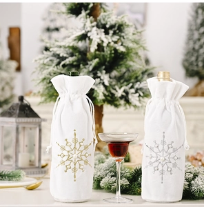 Close-up of white faux fur Christmas wine bottle cover with gold beaded snowflake embroidery