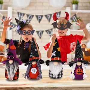 Set di quattro gnomi di Halloween con motivi di zucca e pipistrello su tavolo in legno