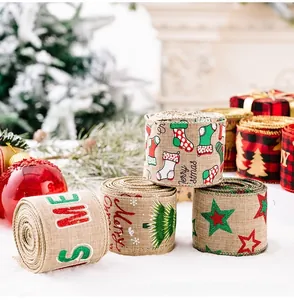 Close-up of Christmas linen ribbon with festive patterns like socks and trees on snow background