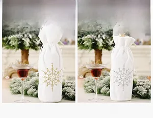 Detailed close-up of gold and silver snowflake embroidery on white velvet wine bottle bags