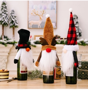 Close-up of festive Christmas gnome wine bottle covers with plush fabric and plaid hats