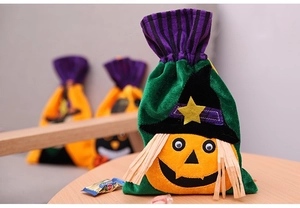 Detail of Halloween drawstring velvet gift bag featuring a green pumpkin character with witch hat