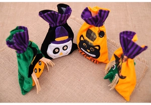 Set of four velvet Halloween drawstring bags featuring ghost, cat, scarecrow, and witch motifs
