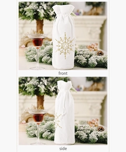 Detail of white velvet wine bottle bag with gold snowflake embroidery and drawstring