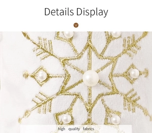 Detailed macro view of white plush fabric with gold snowflake embroidery and pearl accents