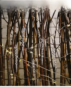 Macro detail of transparent spiral icicle ornaments hanging on a festive Christmas tree branch