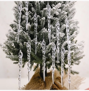 Close-up of transparent spiral icicle ornaments hanging on a snowy Christmas tree