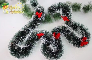 Ghirlanda natalizia verde e bianca con fiocchi rossi, decorazione festiva con effetto neve