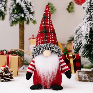 Christmas gnome doll with red green plaid hat and white beard in winter snow scene